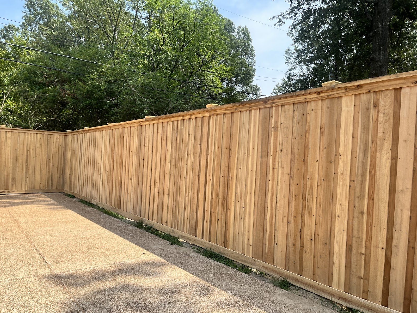 New wood privacy fence along a driveway built by Flawless Fencing