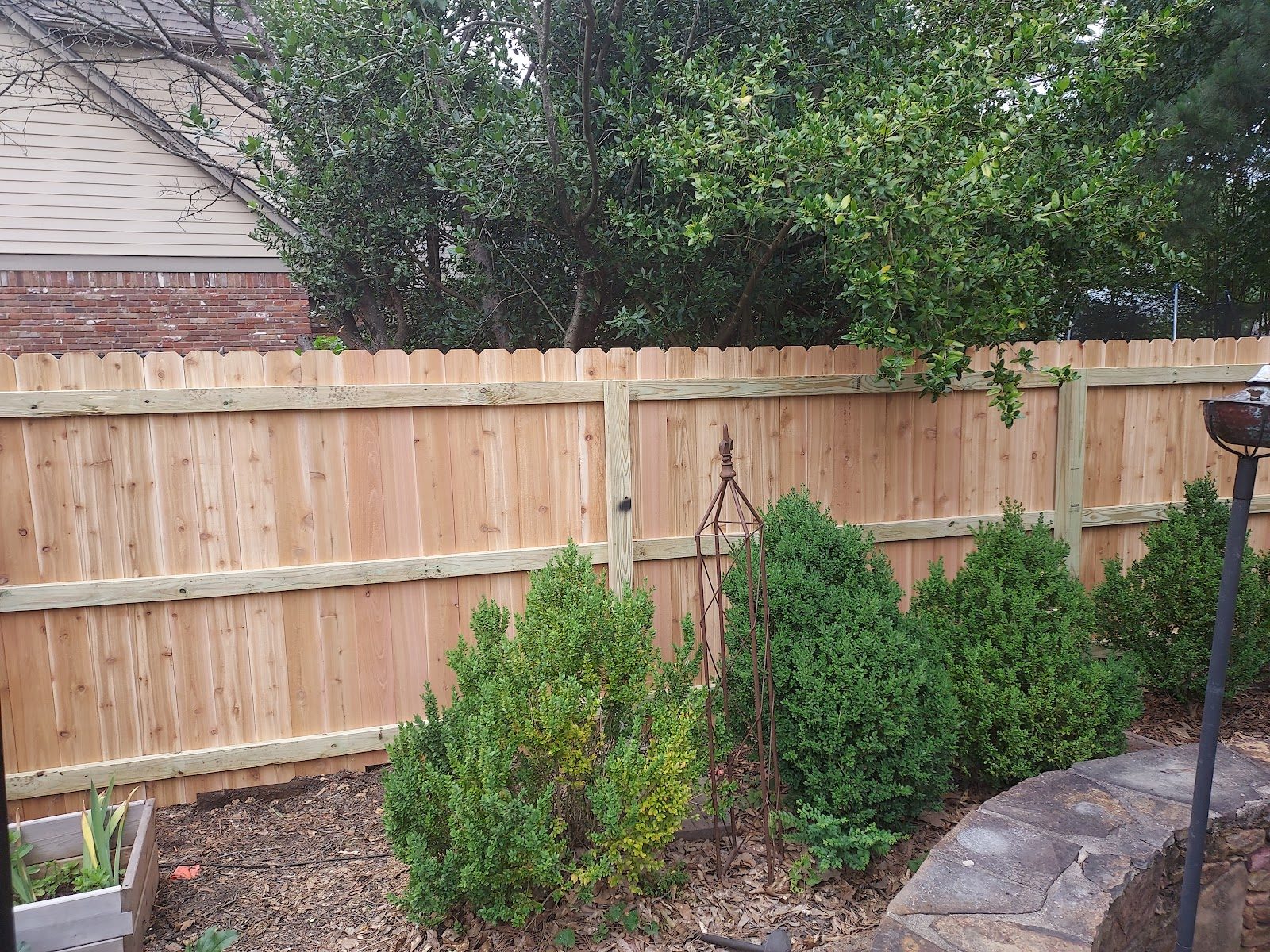 Wood privacy fence behind a planted garden bed